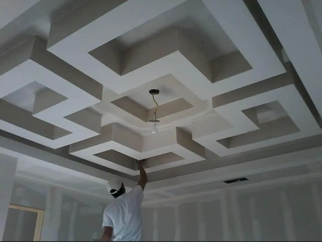 Coffered ceiling with man finishing it