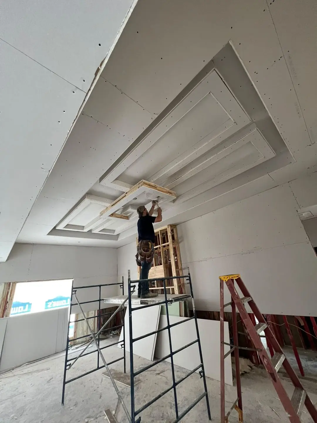 Drywall ceiling install, worker on scaffold