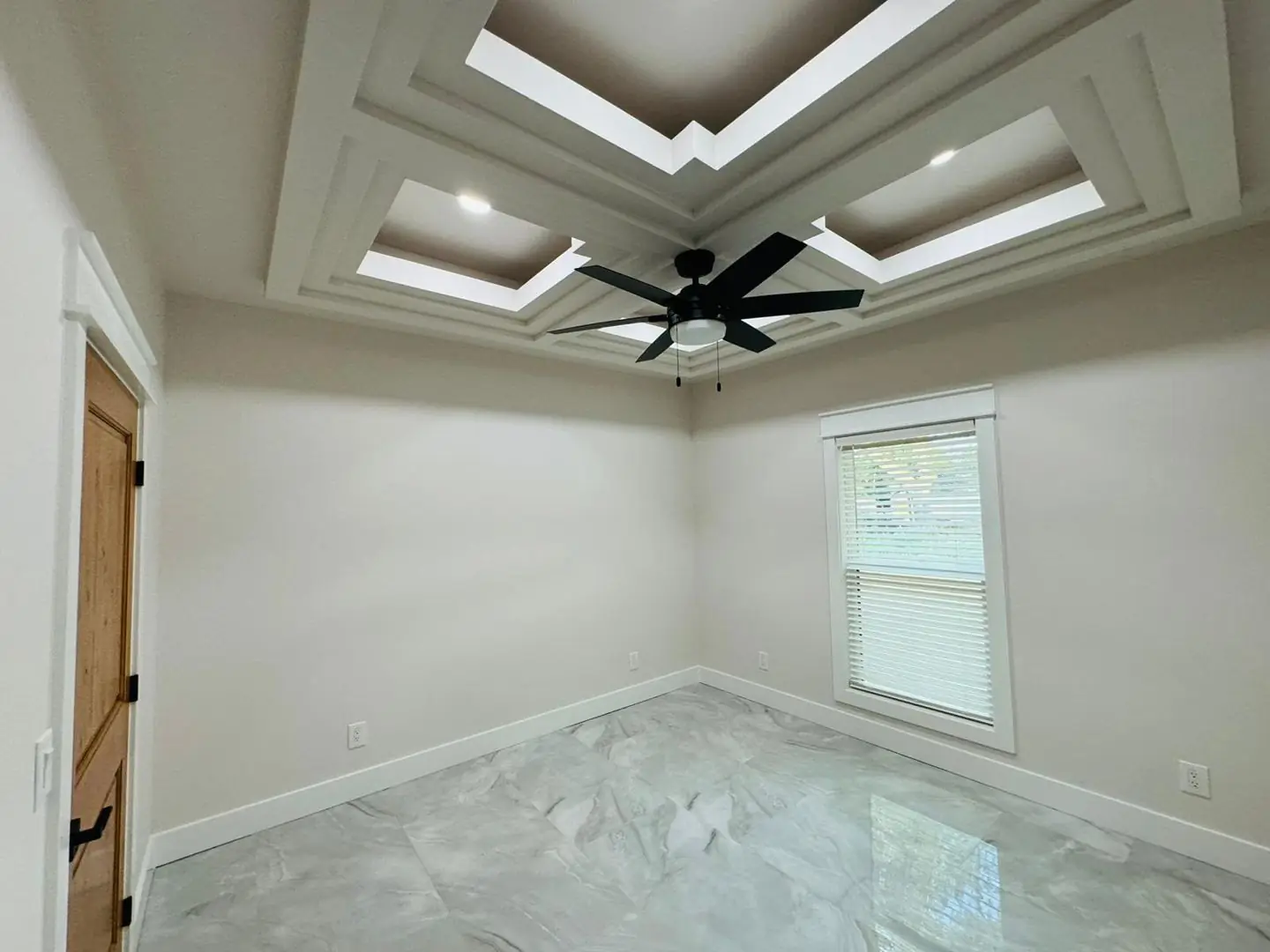 Finished living/kitchen: vaulted beams, fan medallions, marble tile