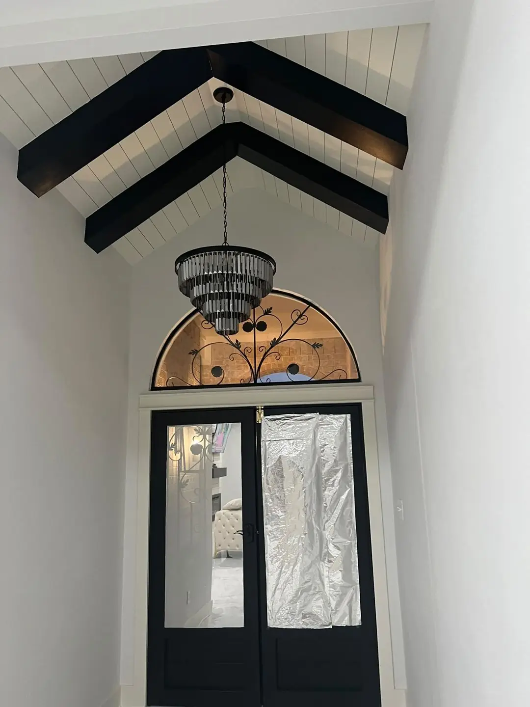 Entry with an arched transom window and chandelier