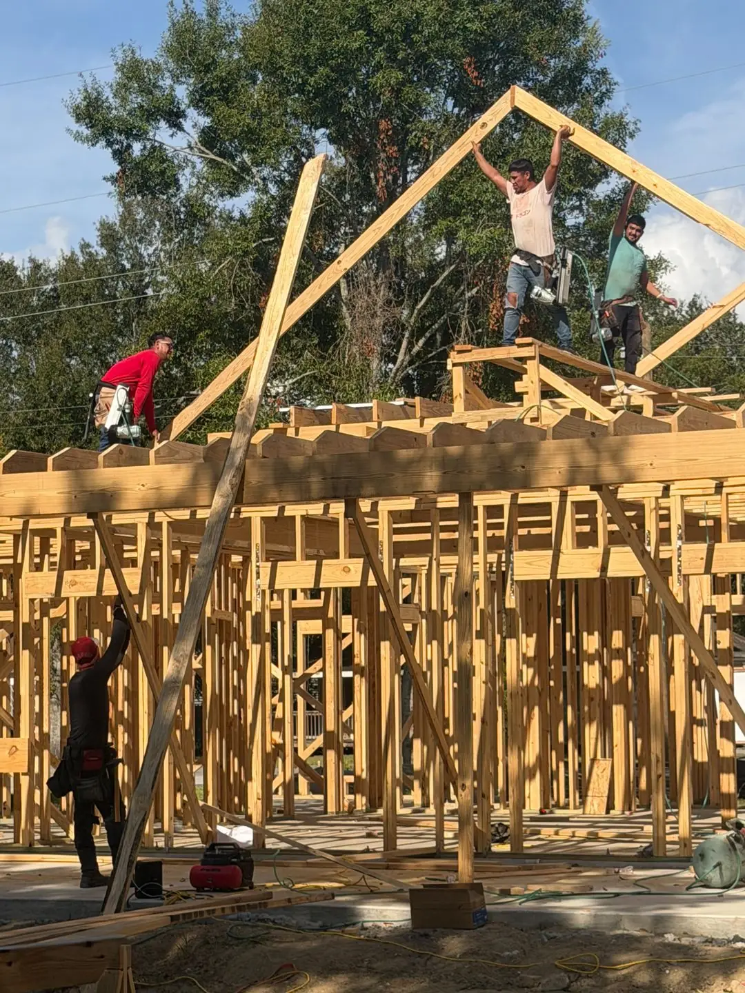 Roof truss framing day with crew on walls, Groves, TX