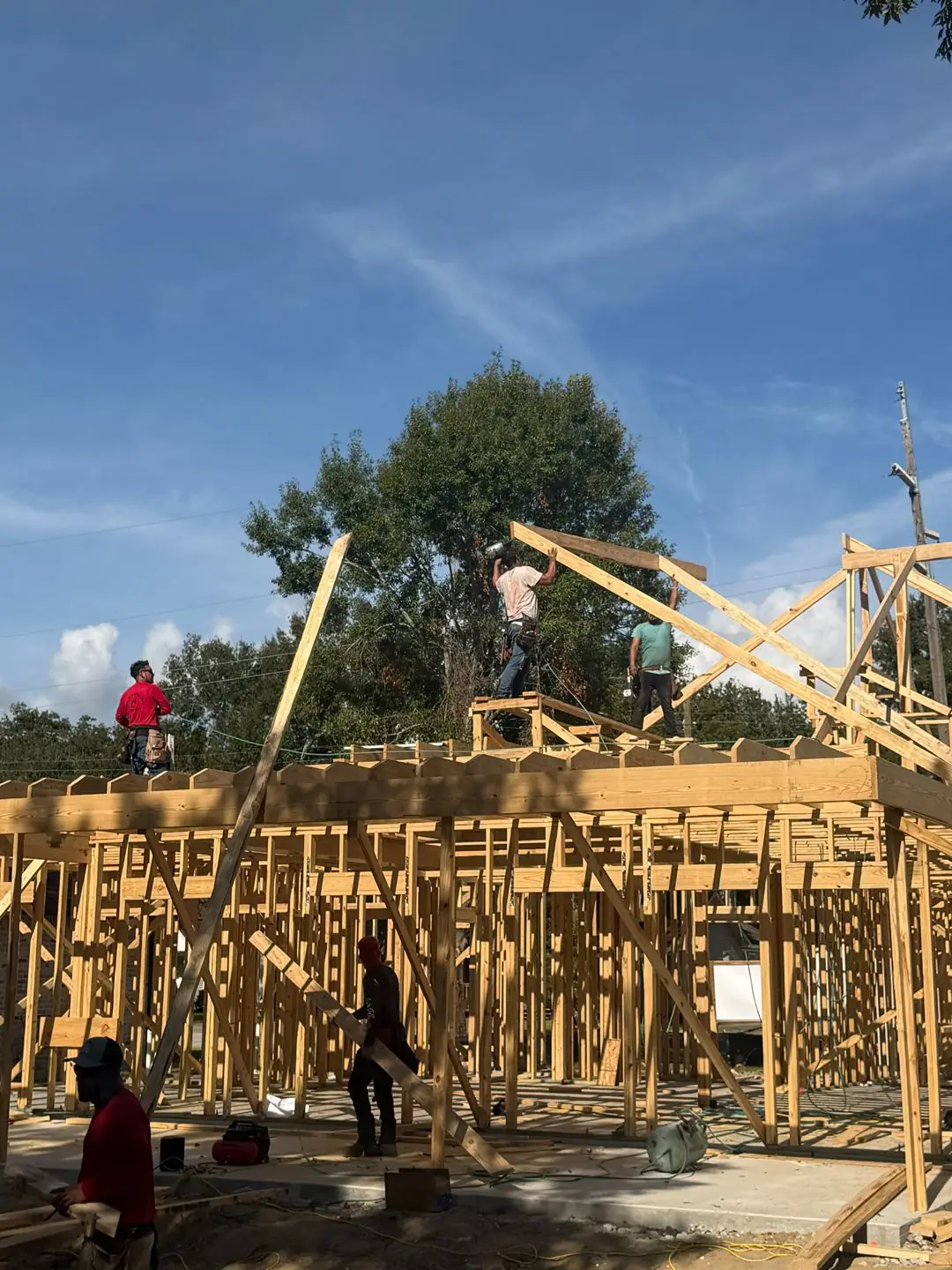 Roof truss framing day with crew on walls, Groves, TX