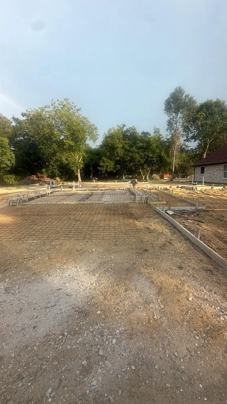Slab forms, rebar, vapor barrier laid, crew prepping