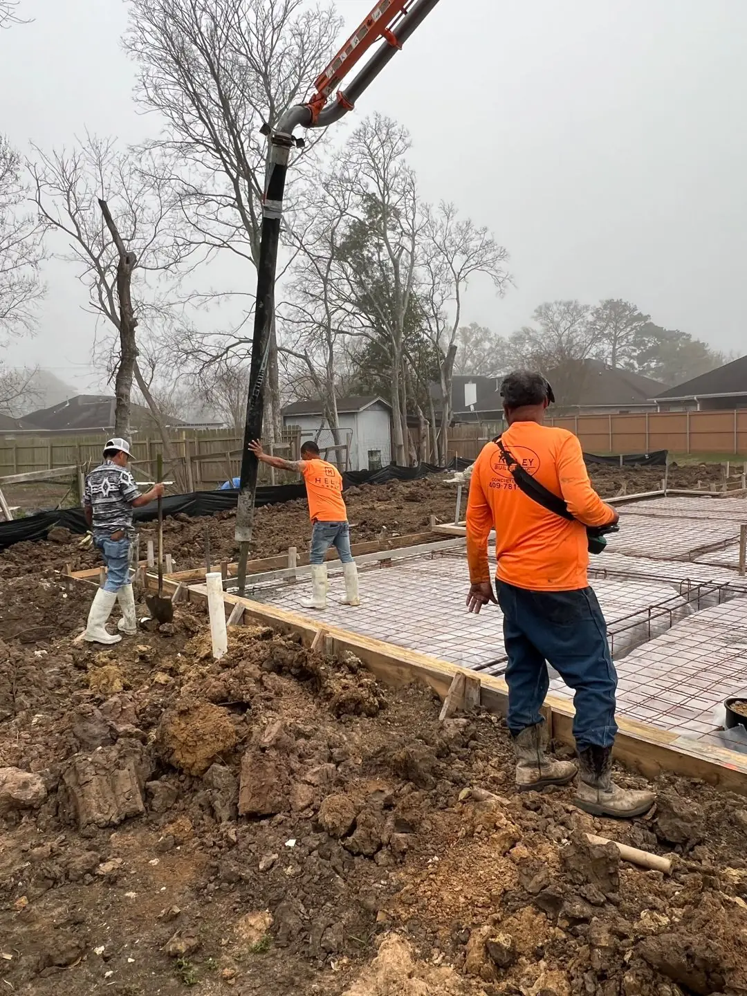 Slab pour with pump truck, rebar mesh, crew in hi-vis