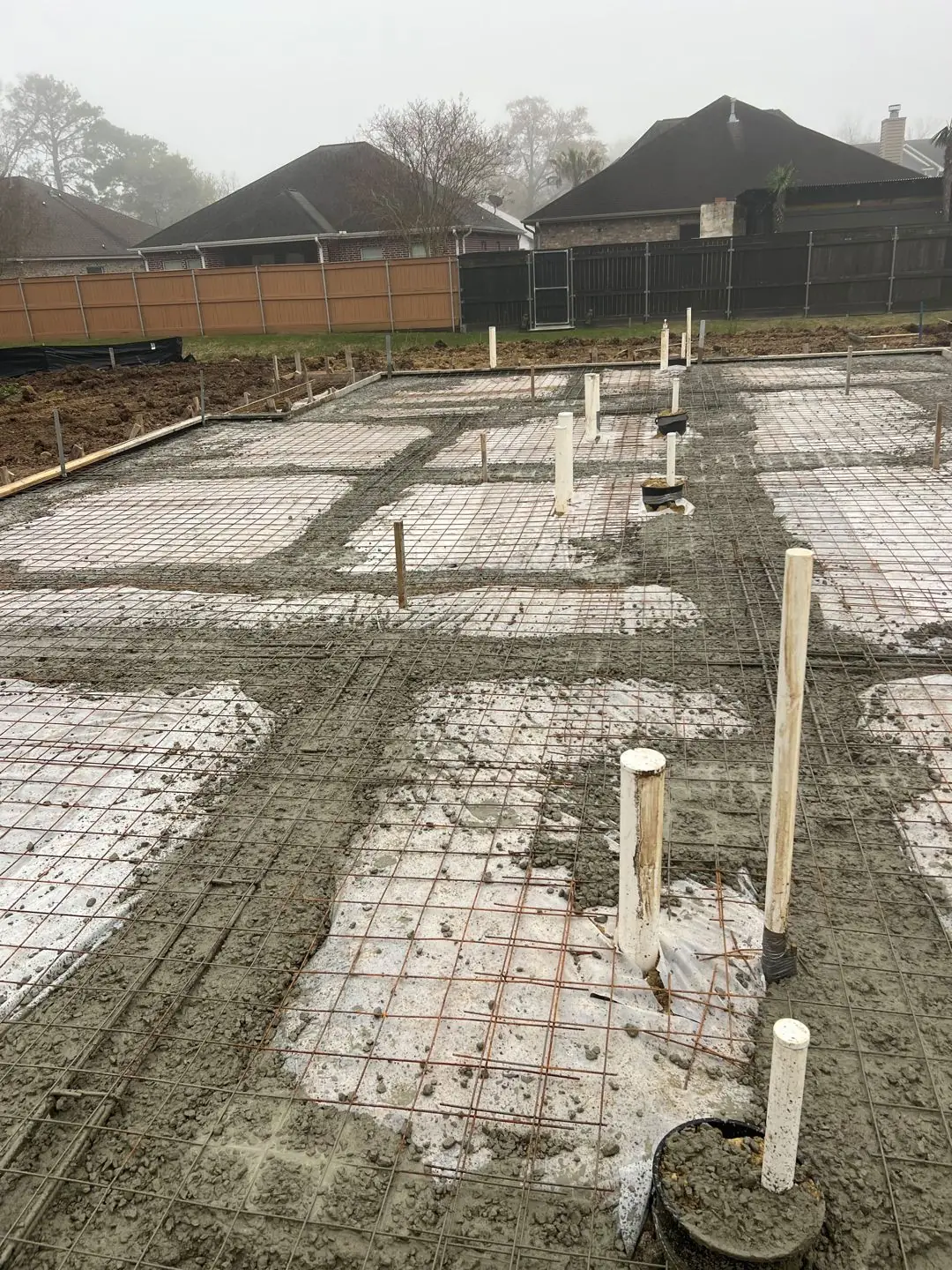 Slab pour with pump truck, rebar mesh, crew in hi-vis