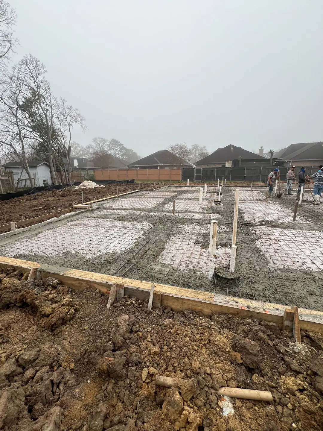Slab pour with pump truck, rebar mesh, crew in hi-vis
