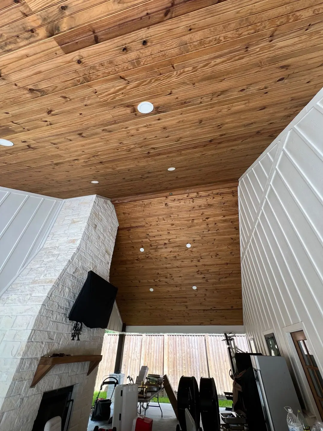 Framing / spray foam / insulation / drywall stages: tray ceilings, scaffold, workers, plumbing PEX manifold, electrical conduit