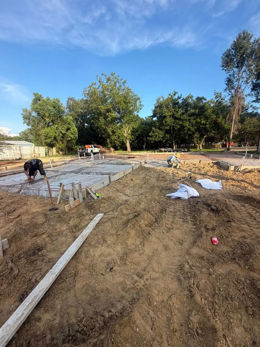 Slab forms, rebar, vapor barrier laid, crew prepping