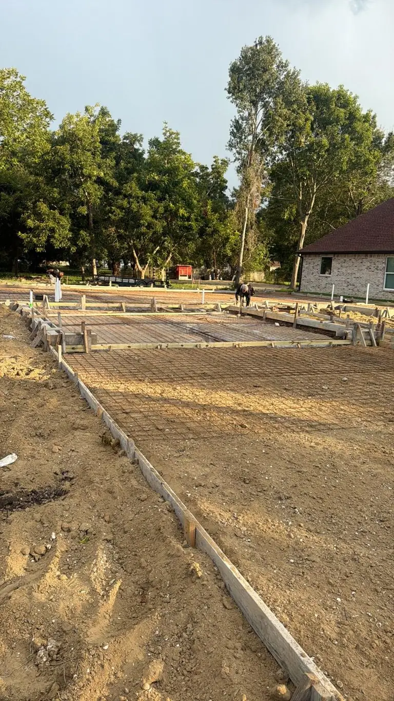 Slab forms, rebar, vapor barrier laid, crew prepping