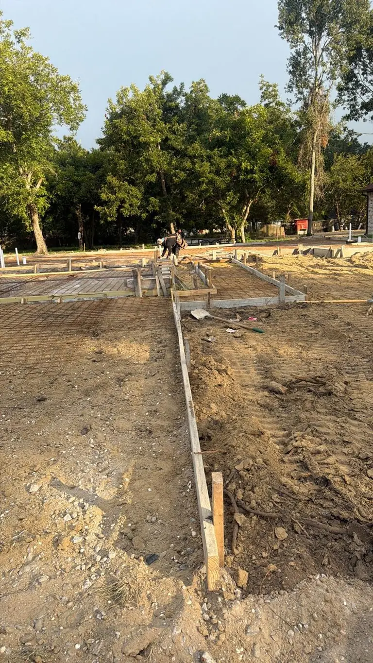 Slab forms, rebar, vapor barrier laid, crew prepping