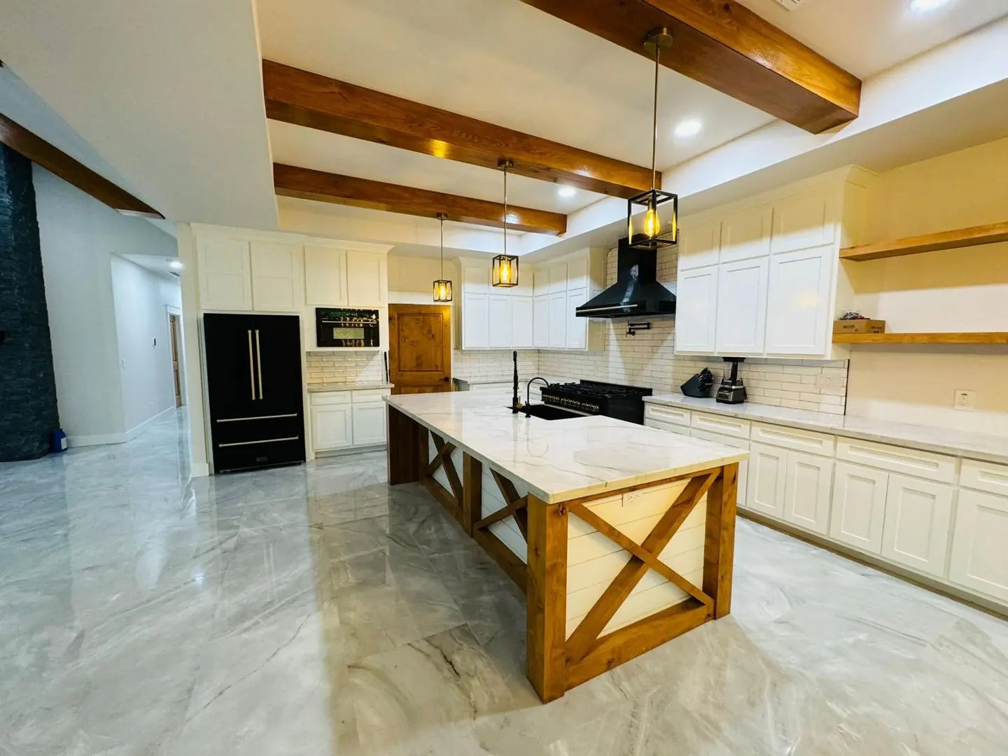 Finished kitchen wide: black fridge, island, beams, Groves, TX