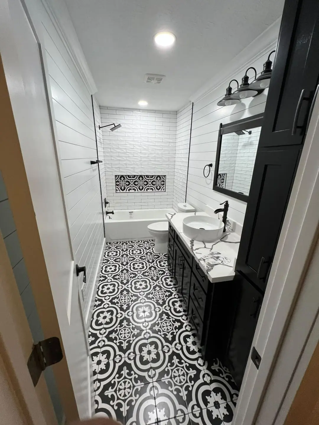 Finished guest bath: patterned black/white floor, shiplap