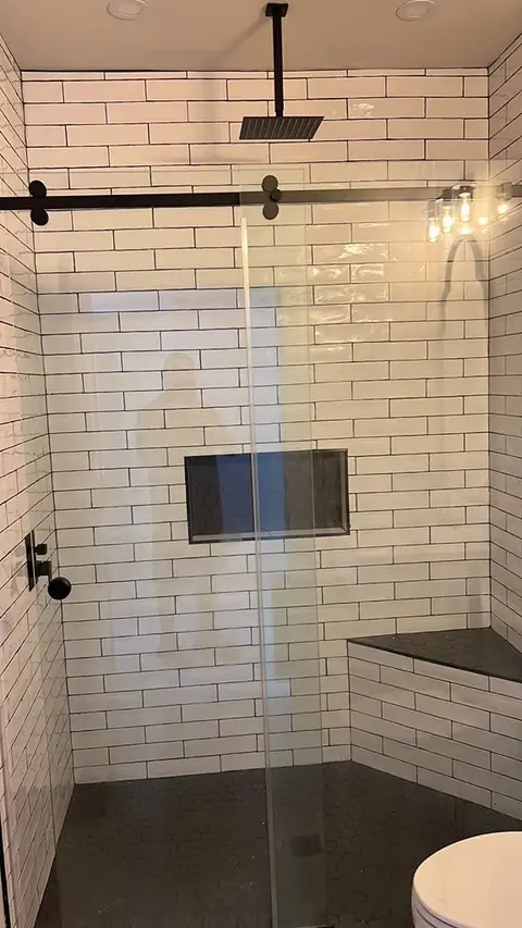 Finished white subway tile shower, black fixtures, glass