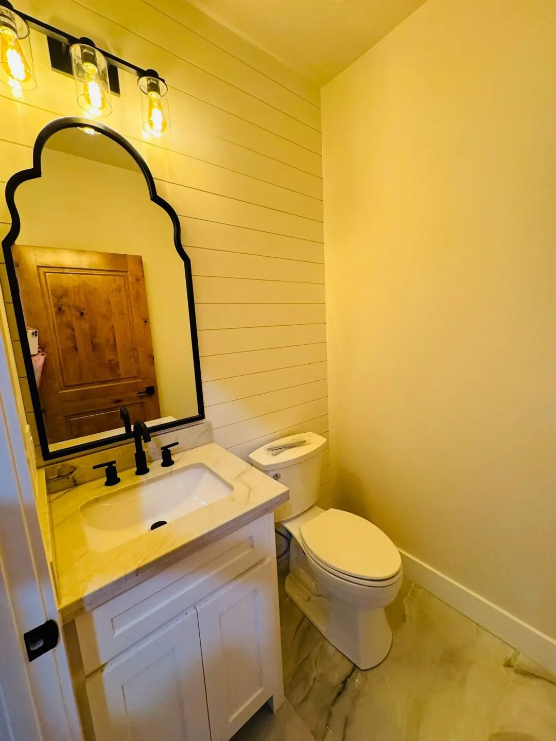 Finished half bath/laundry sink area, round/arched mirrors