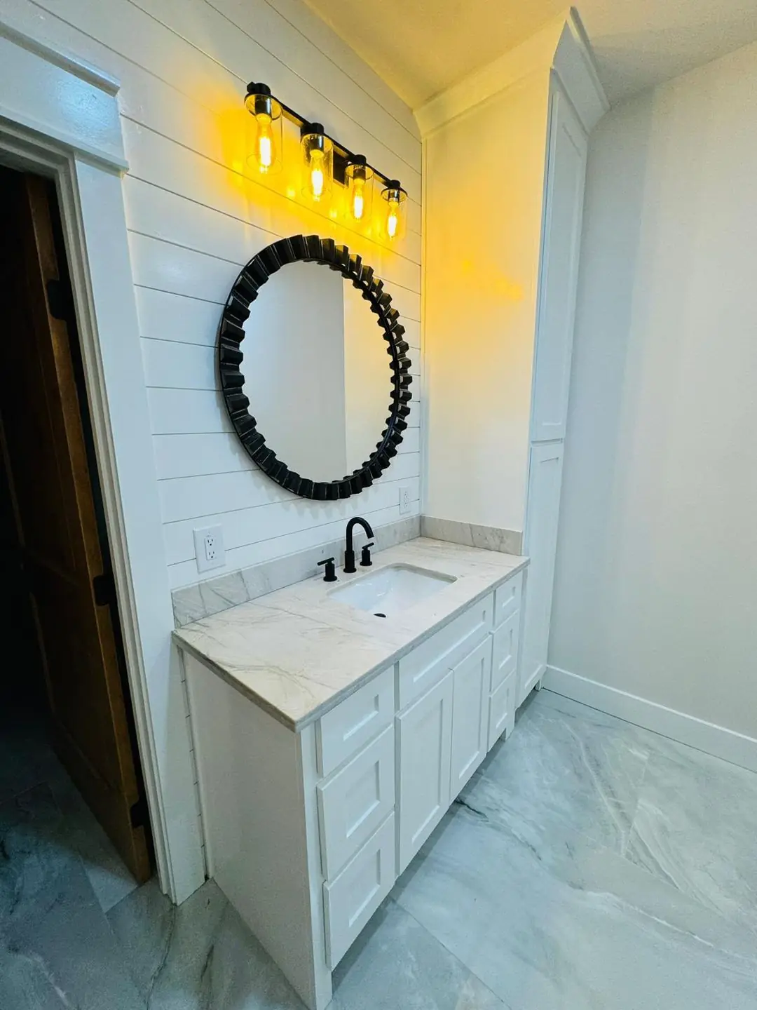 Finished half bath/laundry sink area, round/arched mirrors