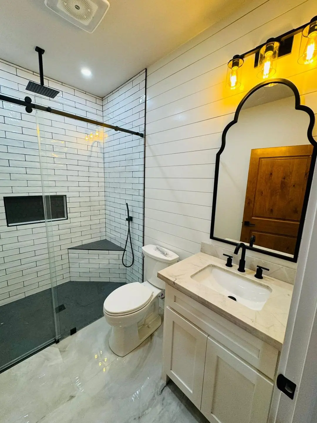 Finished white subway tile shower, black fixtures, glass