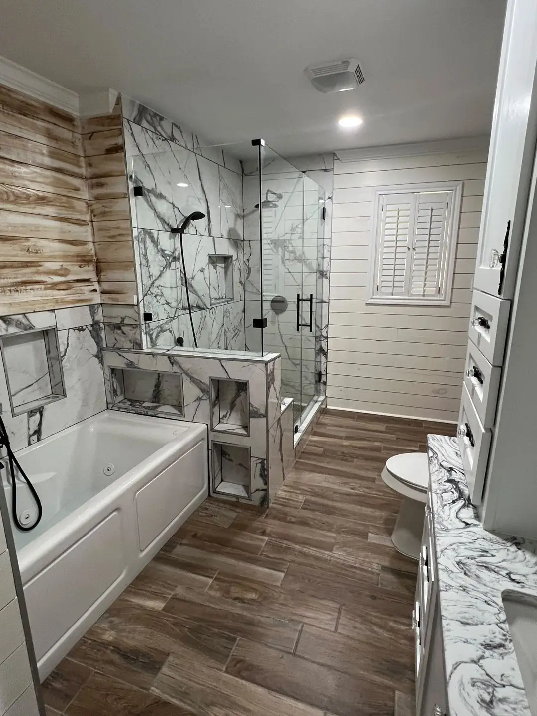 Finished bath: marble shower, shiplap, tub