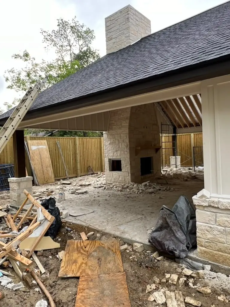 Stone fireplace + metal siding + covered patio under construction