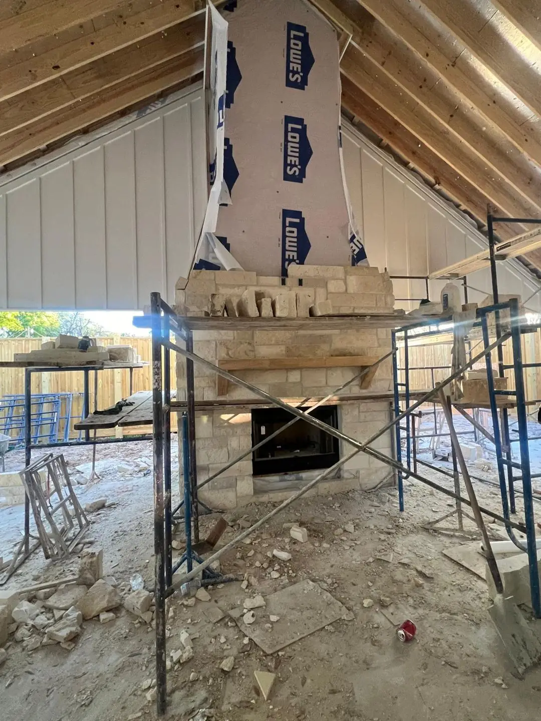 Stone fireplace + metal siding + covered patio under construction, Groves, TX