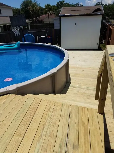 Wood deck + stairs around above-ground pool, railings