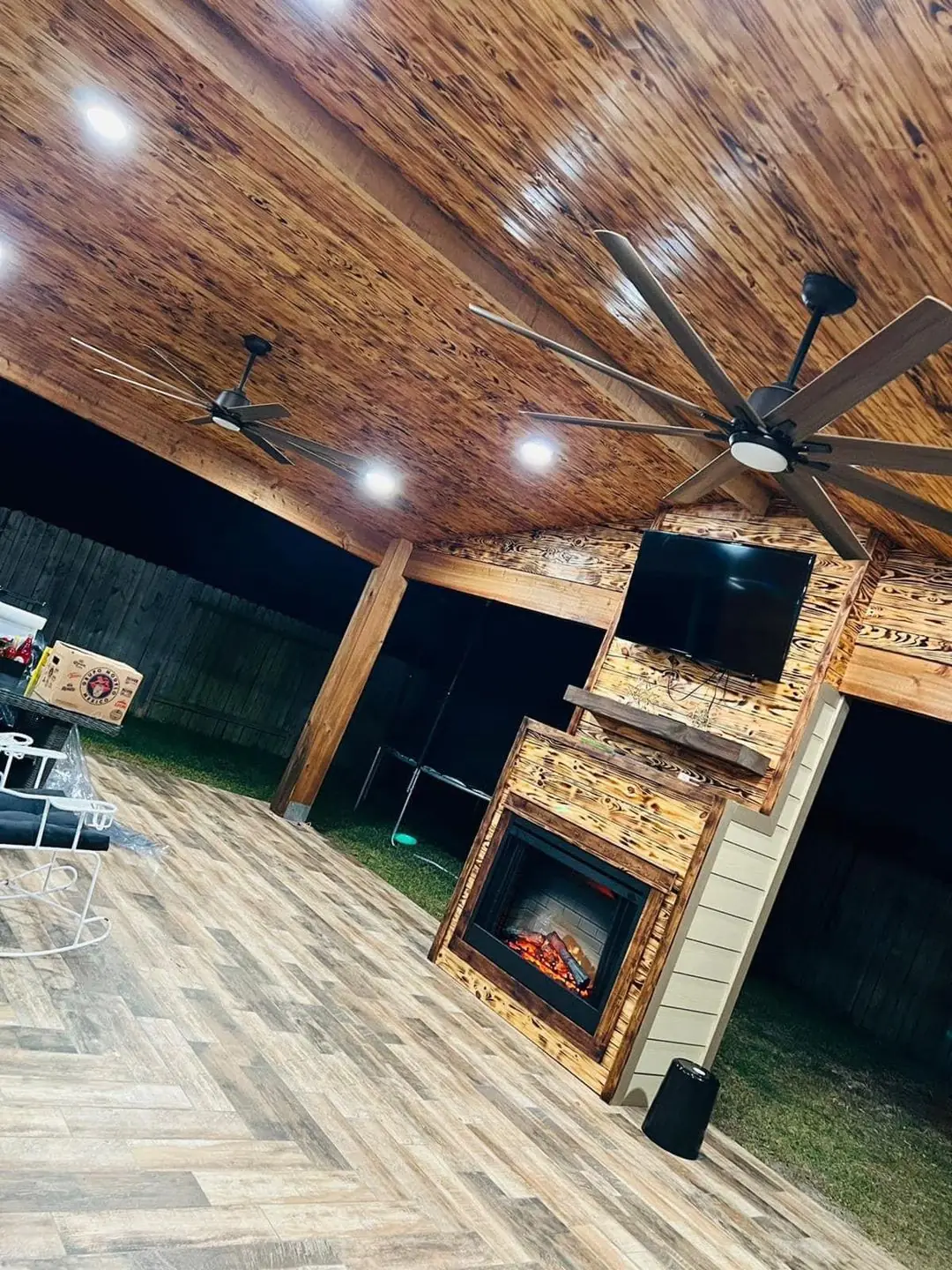 Covered patio finished: pine ceiling, big fan, stone/wood fireplace TV wall, tile floor