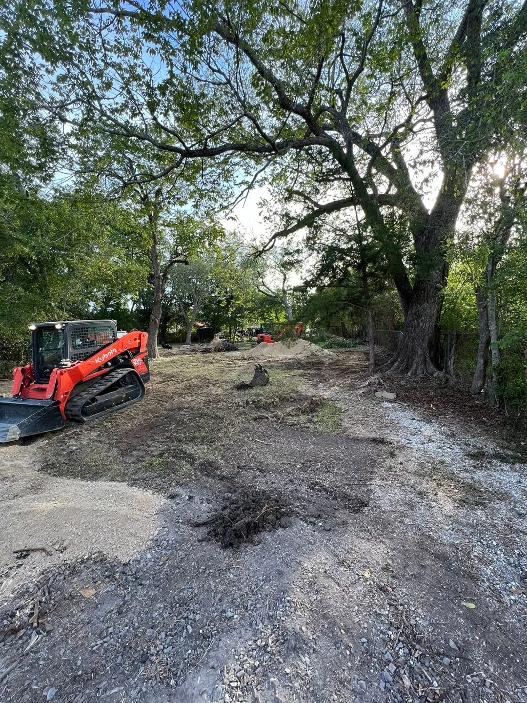 Skid steer grading a cleared lot