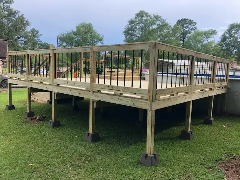 Raised wood deck on piers around an above-ground pool
